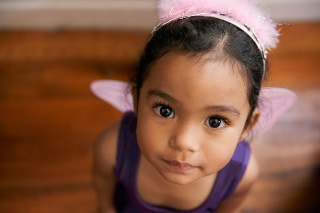 Young girl dressed up as a fairy looking up