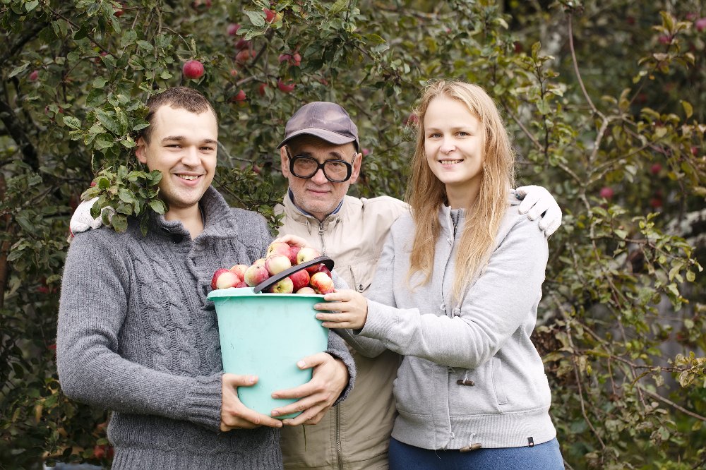 Three people from the Gleaning Program with a bucket of apples